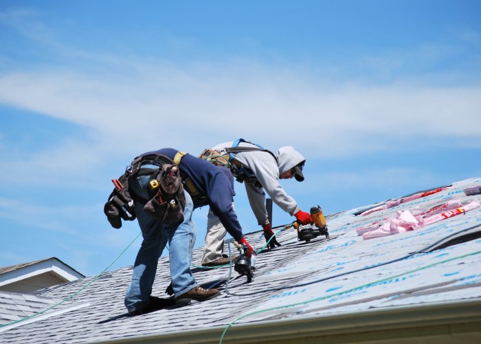 residential roof replacement in Boston - two contractors working on roof